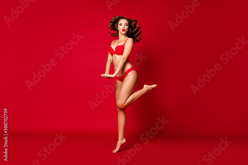 Full length body size view of nice attractive lovely pretty stunning slim fit slender bare foot funny wavy-haired girl jumping sending air kiss isolated bright vivid shine vibrant red color background