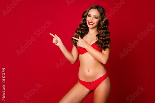 Portrait of attractive lovely alluring chic lovable cheerful wavy girl lady showing demonstrating empty space low price epilation procedure isolated shine vibrant red color background