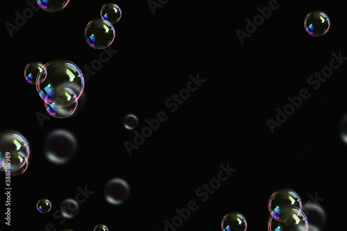 transparent colorful bubbles soap pattern overlay abstract particles splashes of water on black.