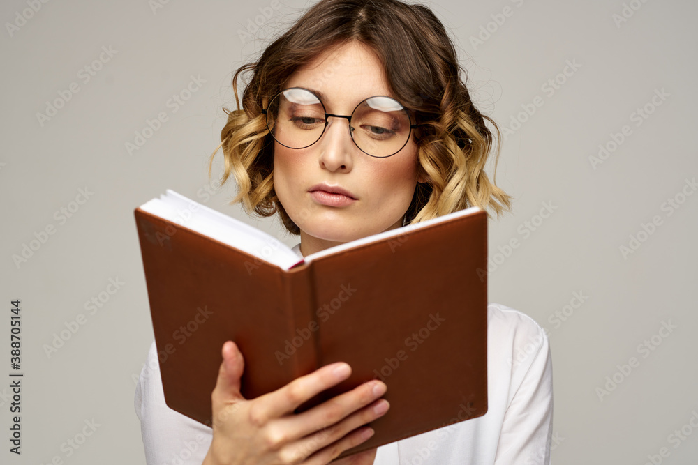 Business woman with notepad and glasses on a light background hairstyle success emotions Business woman with notepad and glasses on a light background hairstyle success emotions
