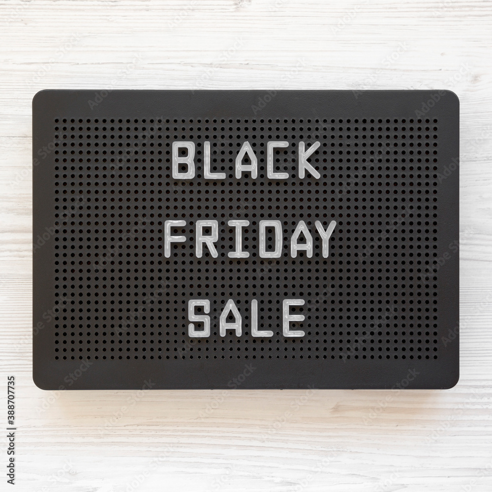 'Black Friday Sale' words on a black lightbox on a white wooden background, top view. From above, overhead, flat lay. 'Black Friday Sale' words on a black lightbox on a white wooden background, top view. From above, overhead, flat lay.