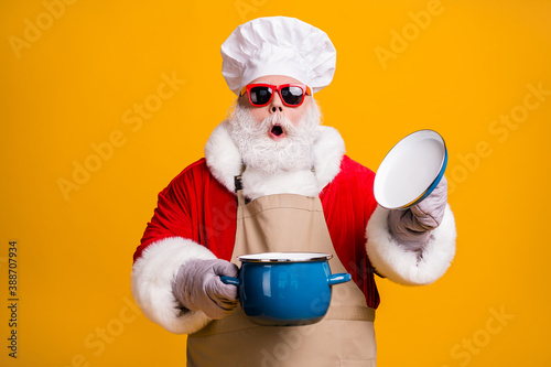 Photo of overjoyed grandpa chef cap hold pan gloves cook family recipe open lid look inside smell amazing aroma wear x-mas red costume coat sun specs apron isolated yellow color background
