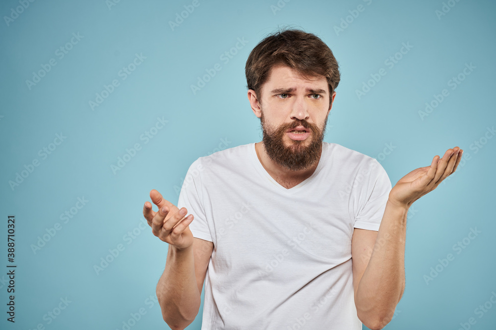 Man in white t-shirt emotions facial expression cropped view studio blue background lifestyle Man in white t-shirt emotions facial expression cropped view studio blue background lifestyle