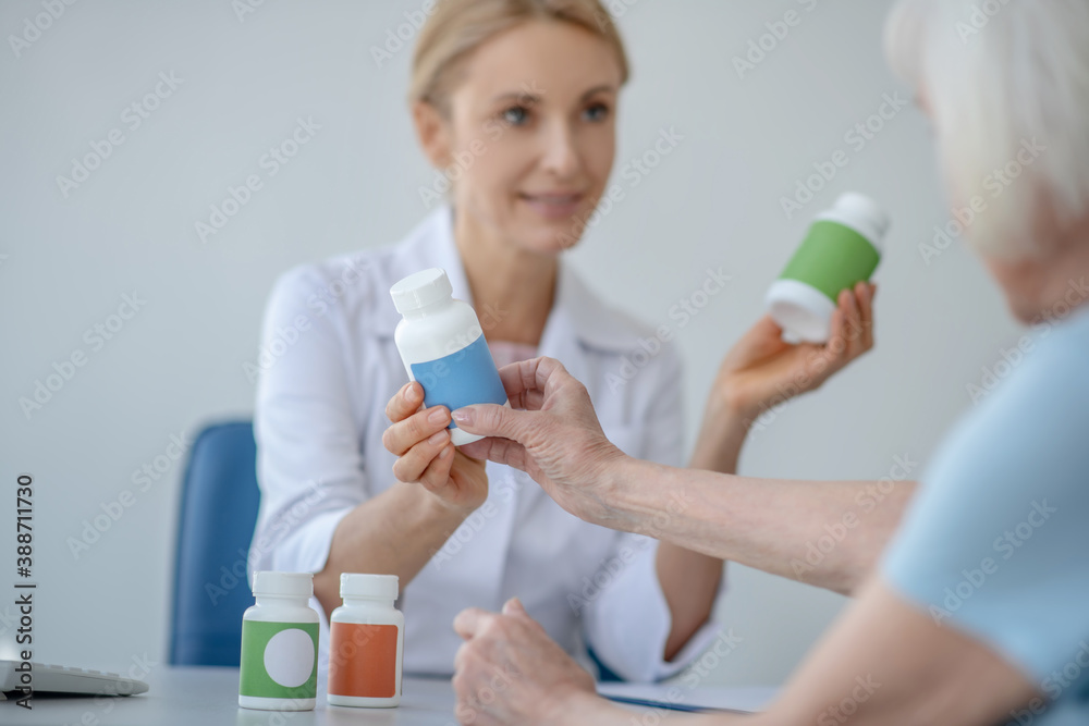 Obraz premium Female doctor talking to elderly patient about medication