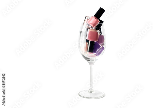 Pink nail polish bottles set. Nail polish bottles in wine glass. Purple nail polsih bottles on isolated background. photo