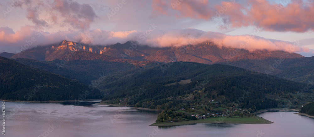 Morning panorama overlooking the Bicaz Lake and with morning light on the stunning Ceahlau Mountains, part of the Romanian Carpathians.