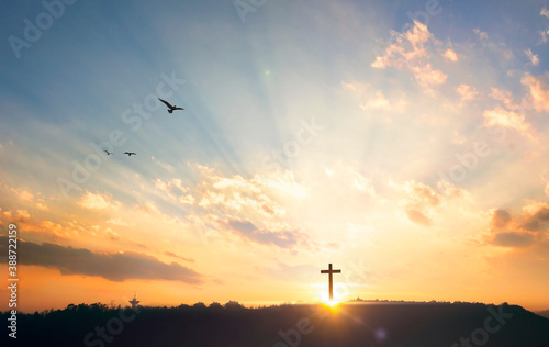 Religious concept: Silhouette cross on mountain at sunset background photo