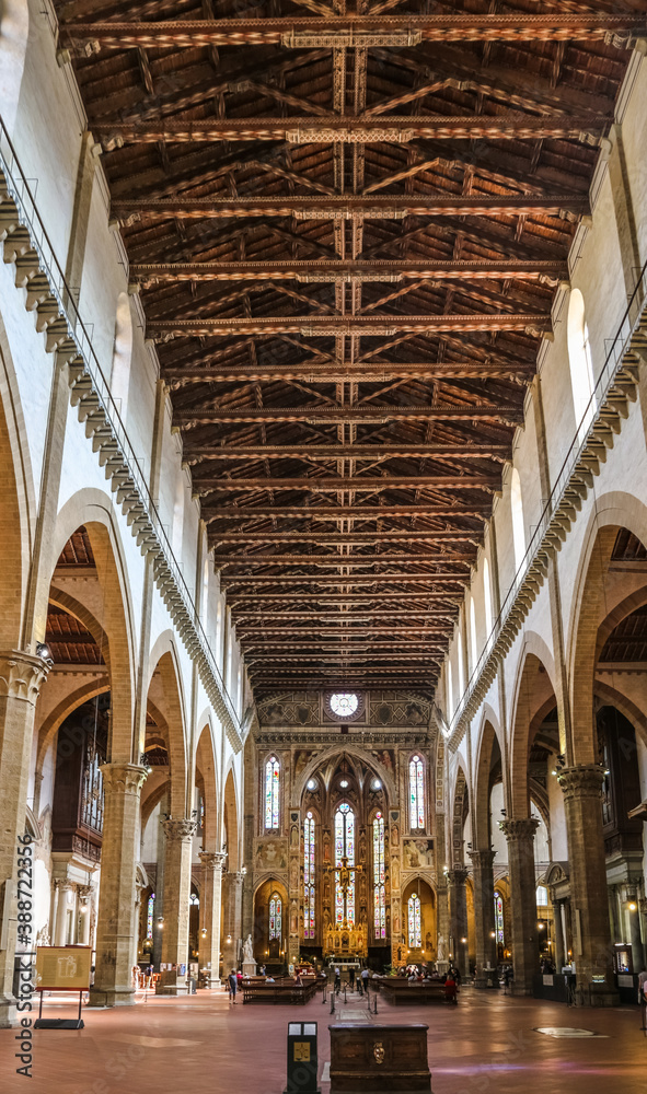 Nice view of the long impressive nave, from the prie-dieu to the main chapel at the apse, with the beautiful wooden ceiling beams inside the famous Basilica of Santa Croce in Florence, Tuscany, Italy.