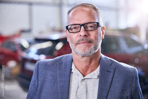 Good-looking bearded man standing in vehicle repair shop