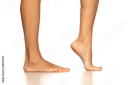 Female bare feet and legs, isolated on white. © Jasmina