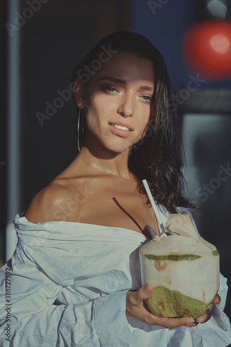 portrait of brunette woman drinking fresh coconut in a cafe