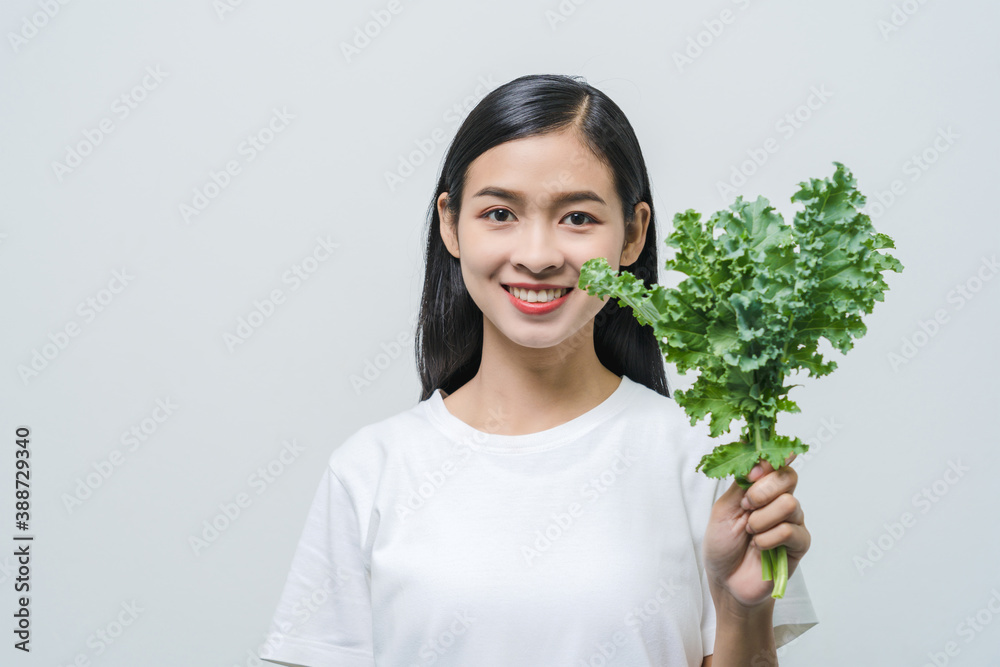 Beautiful young Asian woman with kale leaf in studio. High vitamin vegan food for good health and beautiful skin. Beautiful young Asian woman with kale leaf in studio. High vitamin vegan food for good health and beautiful skin.