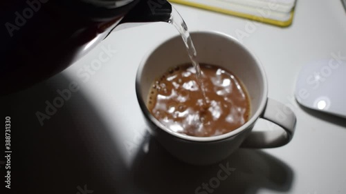 Pour hot water from the kettle to make coffee
