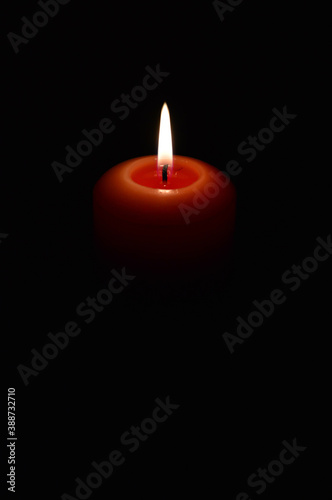 burning candle on a black background. flame of fire