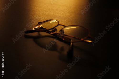 Modern glasses laying on a black table with golden light