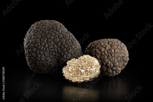 Black truffles group and slice on black, clipping path included