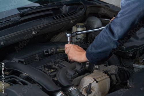 Man tightens spark plug with torque wrench