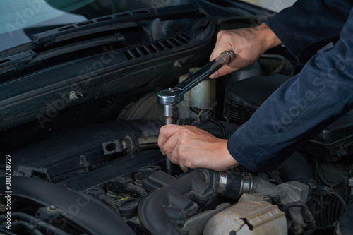 Man tightens spark plug with torque wrench