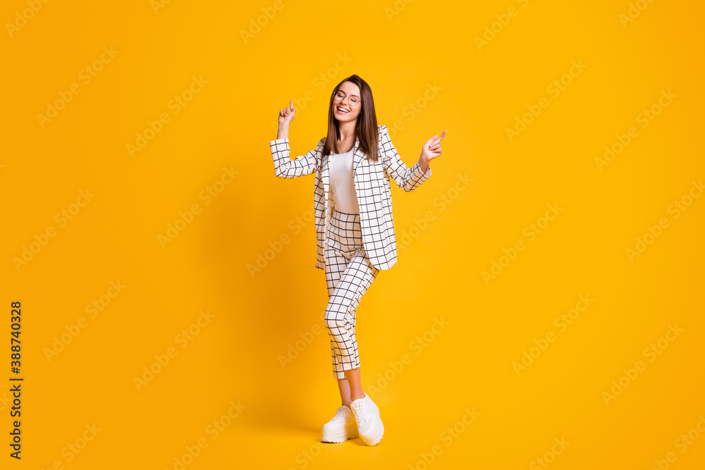 Full length body size photo of dancing woman wearing round eyeglasses enjoying music isolated on bright yellow color background