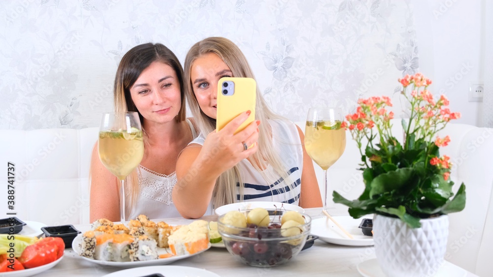 Two girls laughing girls talking on video communication on smartphone at home, selective focus Two girls laughing girls talking on video communication on smartphone at home, selective focus