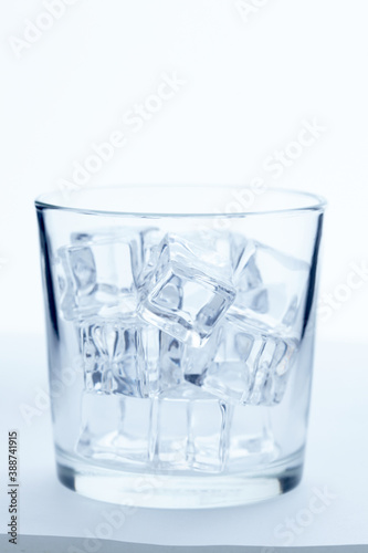 glass with ice cubes on white background