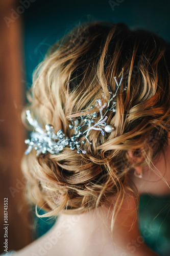 Hairstyle with beads and wire decoration. Copper and brown hair color. Wedding hairstyle of the bride back view. Selected focus. Blurred background