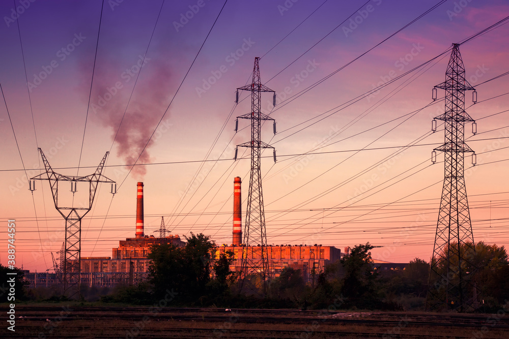 Fototapeta premium Power station with smoking chimney among electric wires