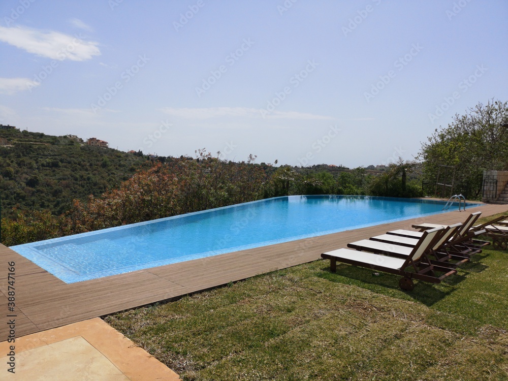 Infinity swimming pool and chair with valley view. Summer season and travel destination. Best place to relax and spend the day with family. Infinity swimming pool and chair with valley view. Summer season and travel destination. Best place to relax and spend the day with family.