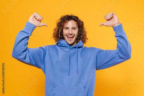 Fotografie Cheerful young man posing isolated over yellow