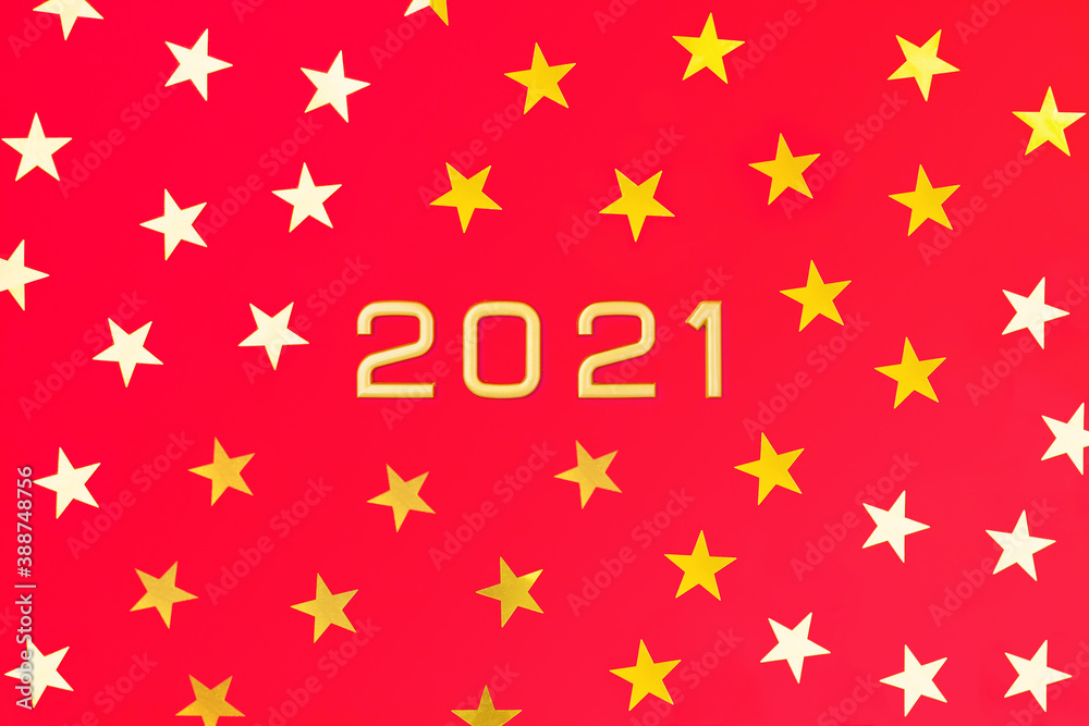 Numbers 2021 among gold yellow and white five-pointed stars on a red background. New Year postcard. Flatly, top view