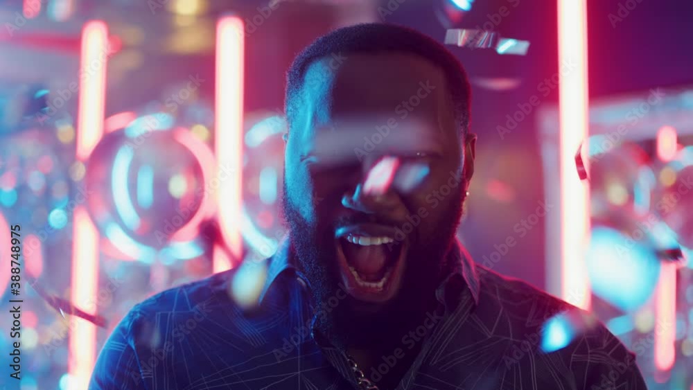 African american man enjoying party. Afro guy throwing up confetti in club African american man enjoying party. Afro guy throwing up confetti in club