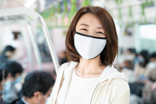 Young Asian woman wearing Surgical face mask at train.