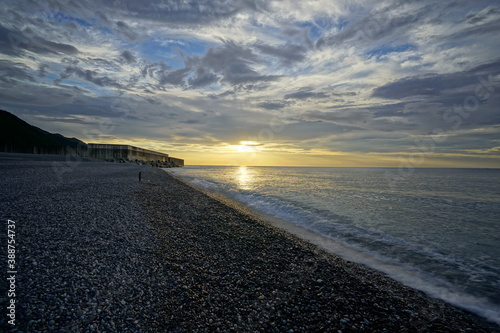 Sunset over the sea. A small round stone beach. Japanese landscape.