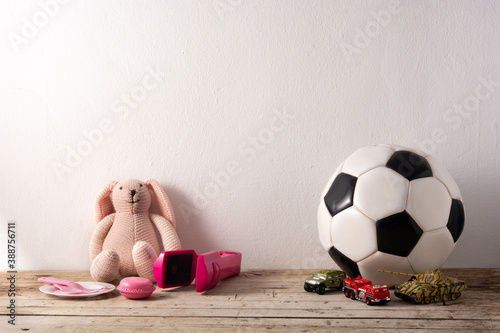 Фотография Gender stereotype toys on wooden table and white background