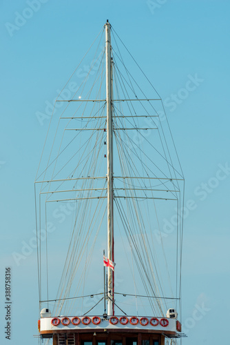 Mast of a ship without sails close up on sky background
