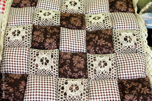 A pillow made of various pieces of brown shades.