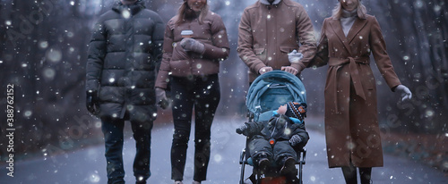 winter walk in the park, young family with a small child and friends, young parents outside seasonal look