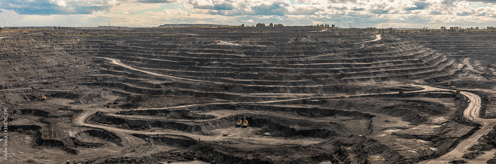 Panoramic aerial view of coal mine. Open pit mine industry, big yellow mining truck for coal quarry. Open coal mining anthracite mining. Pit on coal mining by open way. Rock loading in trucks - obrazy, fototapety, plakaty 