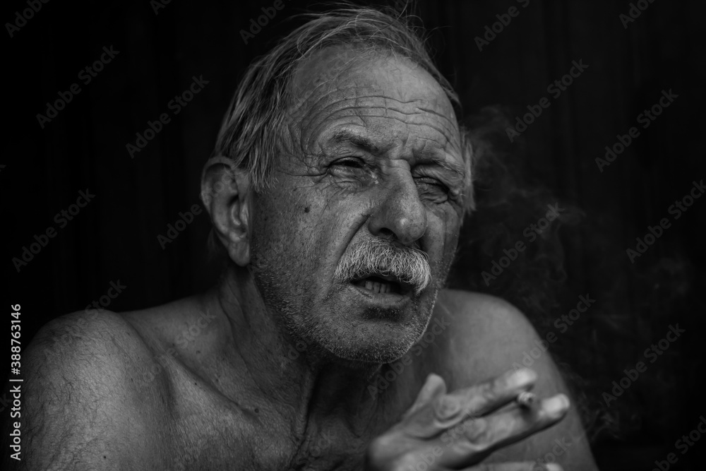 Fototapeta premium portrait of a smocking old man
