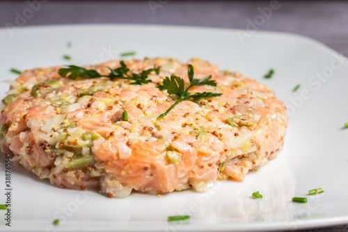 Tartar de salmón en un primer plano decorado con hierbas y cilantro