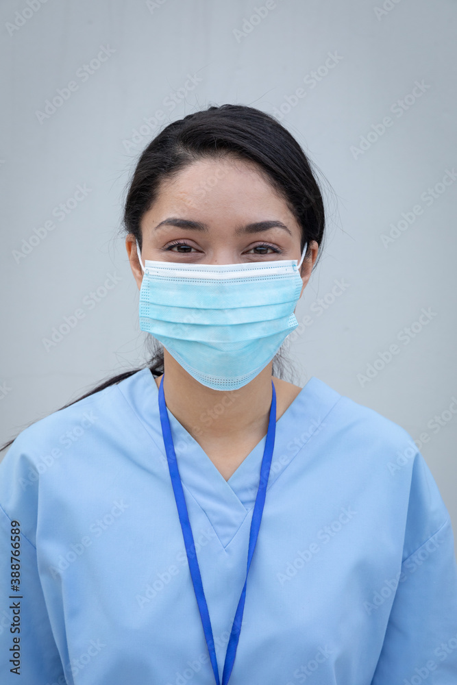 Portrait of female health professional wearing face mask against grey background Portrait of female health professional wearing face mask against grey background