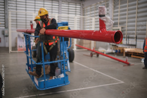Install fire sprinkler system. In the industrial plant, pipe assembly, red fire pipe, fire protection contractors Using Scissor Lift High work