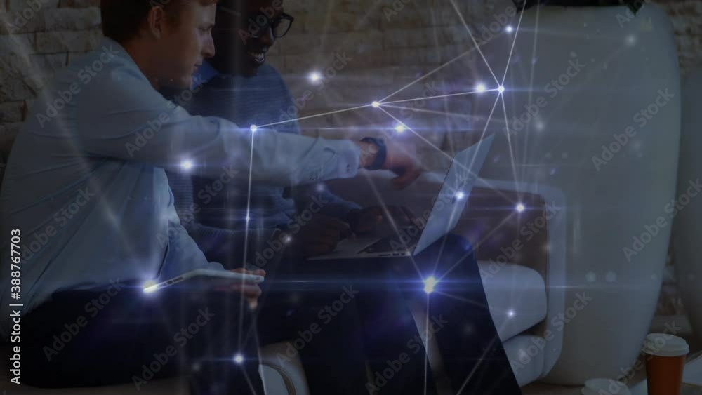 Glowing network of connections against office colleagues using electronic devices