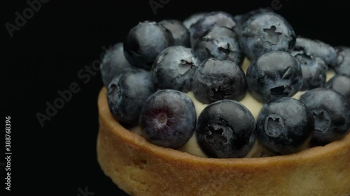 Tasty homemade blueberry tart on the black background, closeup of delicious dessert mini tartalet with fresh berries photo