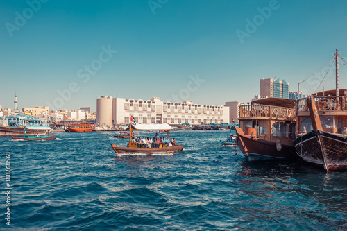 Panoramic view from water taxi boats pier in Dubai, UAE. Creek gulf and Deira area. United Arab Emirates famous tourist destination. Creative color post processing.