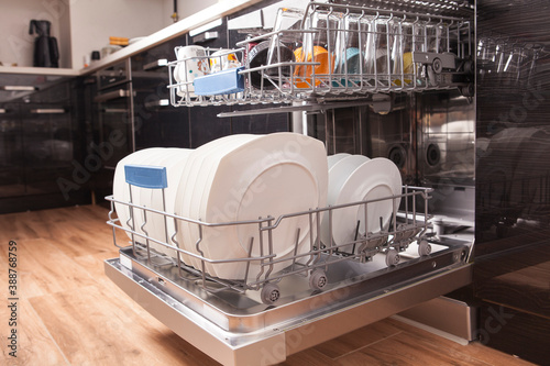 Open dishwasher with clean dishes in the kitchen.