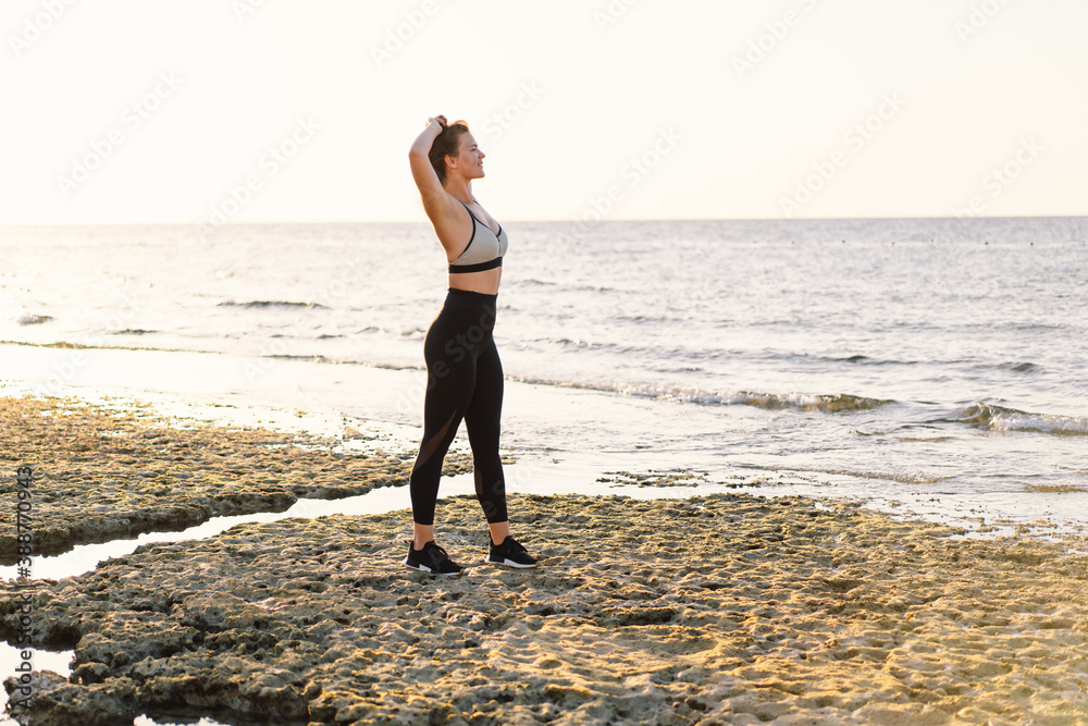 Young girl doing yoga fitness exercise outdoor in beautiful sea and morning sunrise. lifestyle. Healthy and Fitness Concept