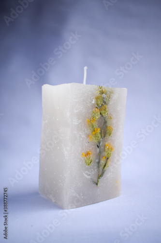 white decoration candle with a flower inside it with horizontal studio background photo