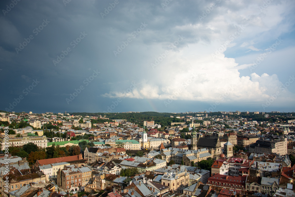 Panorama of the city of Lviv under thick clouds with a sunny glimpse.