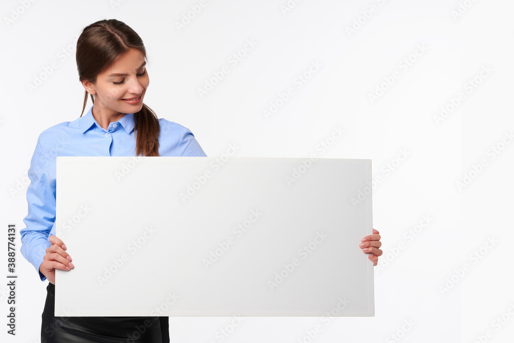 Attractive businesswoman in shirt holding white blank billboard and smiling on white isolated background Attractive businesswoman in shirt holding white blank billboard and smiling on white isolated background